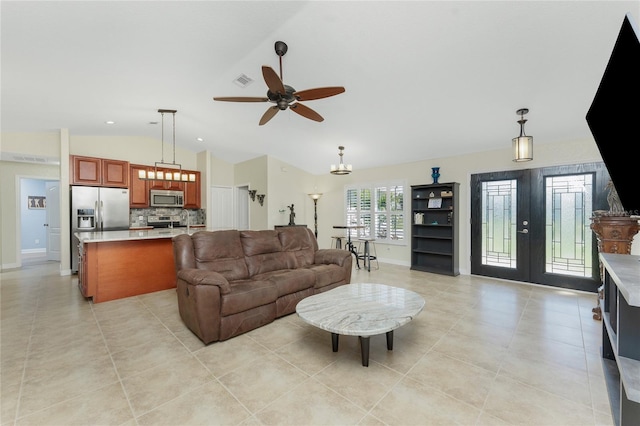 living area featuring light tile patterned floors, visible vents, a ceiling fan, vaulted ceiling, and french doors