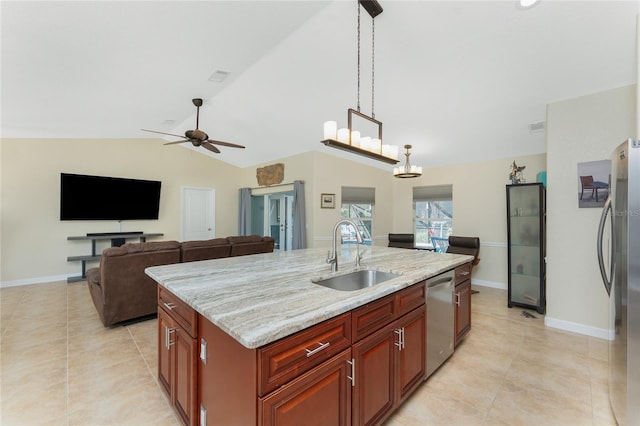 kitchen featuring light stone counters, decorative light fixtures, stainless steel appliances, vaulted ceiling, and a sink