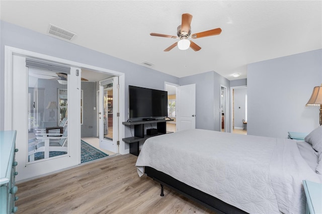 bedroom featuring a ceiling fan, visible vents, and wood finished floors