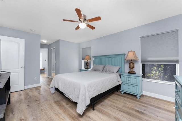 bedroom with light wood-style flooring, baseboards, and ceiling fan