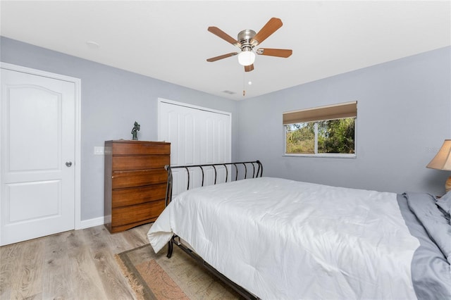 bedroom with baseboards, visible vents, a ceiling fan, light wood-style flooring, and a closet