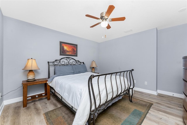 bedroom featuring ceiling fan, light wood-type flooring, visible vents, and baseboards