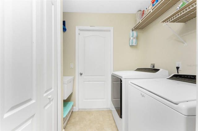 washroom featuring laundry area, independent washer and dryer, and light tile patterned floors