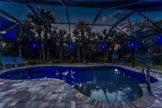 outdoor pool featuring a patio and glass enclosure