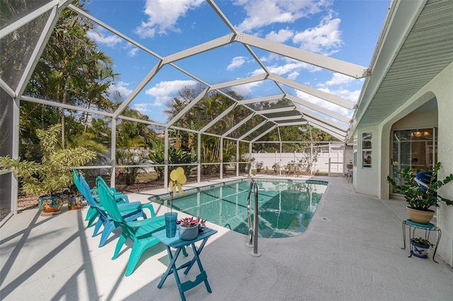 view of pool with glass enclosure, a fenced backyard, a fenced in pool, and a patio