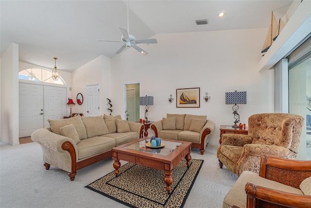 living room featuring visible vents, high vaulted ceiling, ceiling fan, and light colored carpet