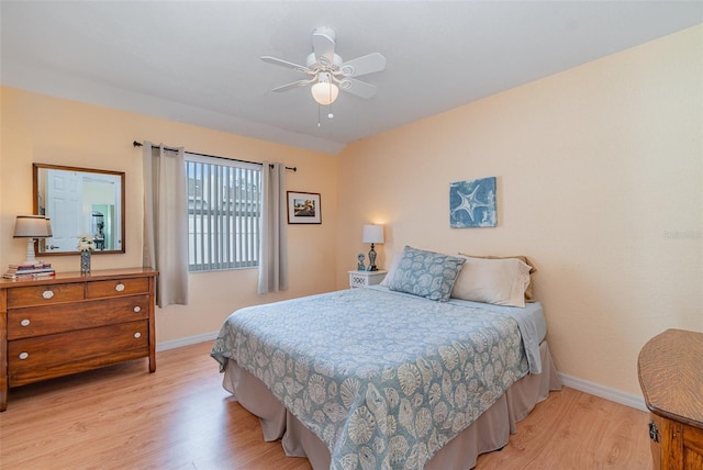 bedroom with baseboards, ceiling fan, and light wood-style floors