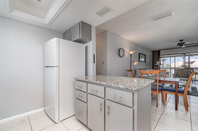 kitchen featuring ceiling fan, light tile patterned floors, gray cabinetry, visible vents, and freestanding refrigerator