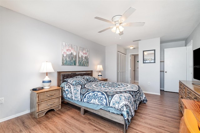 bedroom featuring a closet, baseboards, and wood finished floors