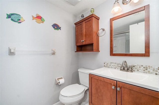 bathroom featuring toilet, backsplash, and vanity