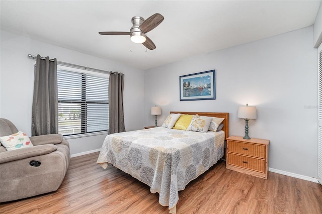 bedroom with ceiling fan, wood finished floors, and baseboards