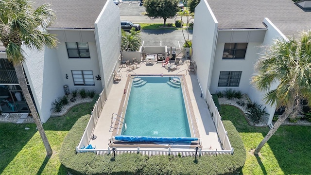 view of swimming pool featuring a fenced backyard, a lawn, and a patio