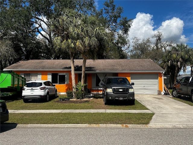 single story home with a garage, driveway, and a front yard