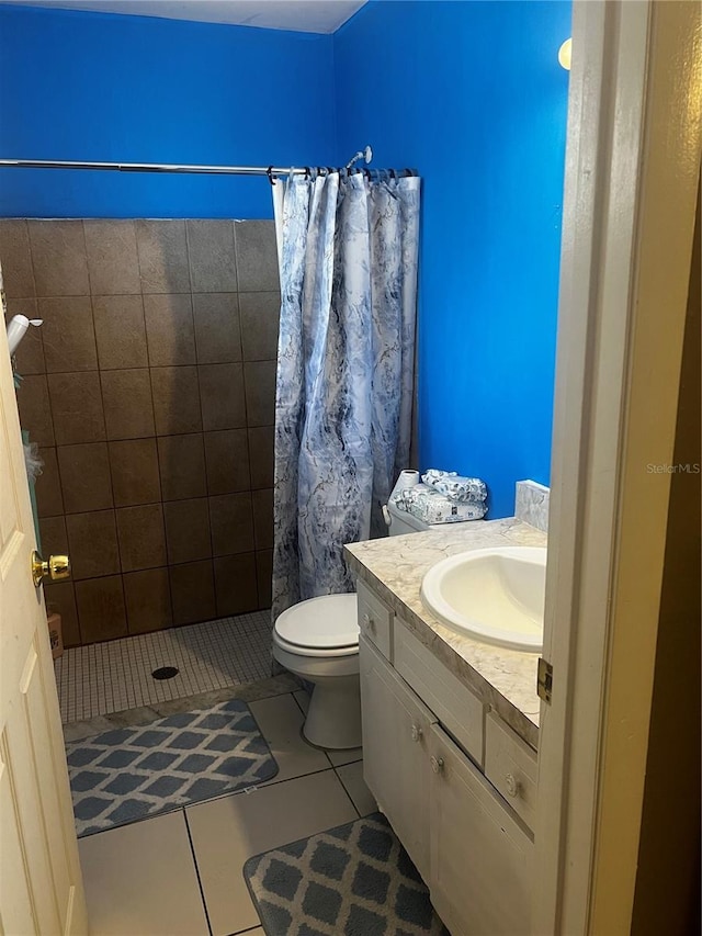 bathroom with toilet, a shower stall, vanity, and tile patterned floors