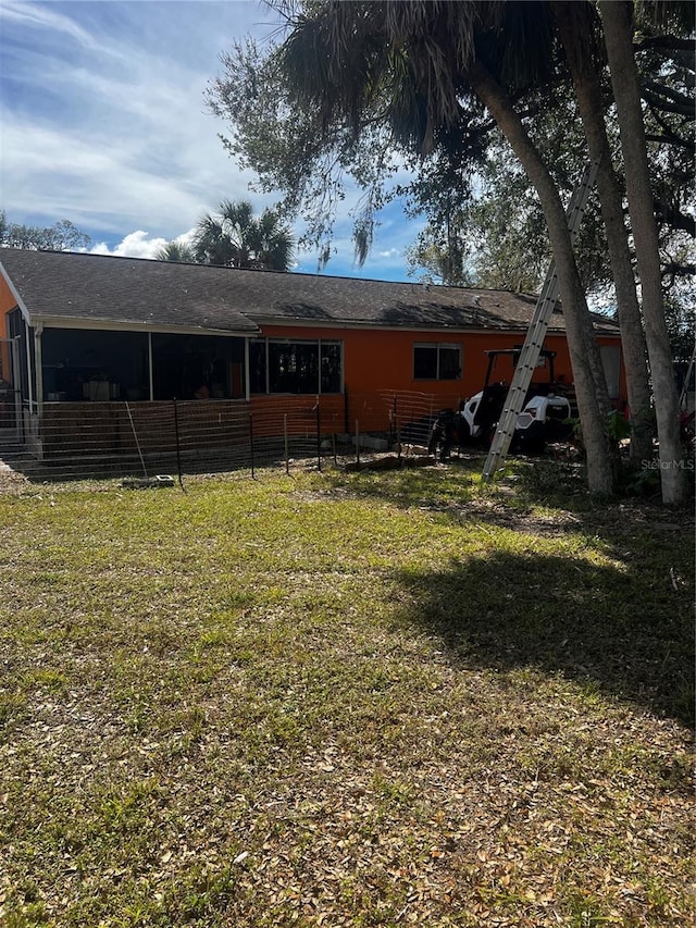 rear view of property with a yard and fence