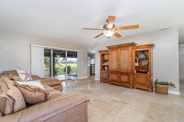 living area featuring visible vents, baseboards, and a ceiling fan