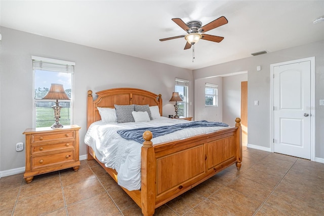 bedroom with a ceiling fan, light tile patterned flooring, visible vents, and baseboards