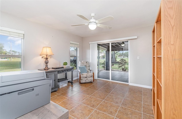 sitting room featuring a ceiling fan, baseboards, and tile patterned floors