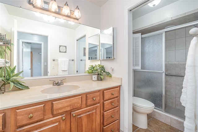 full bathroom featuring vanity, a shower stall, toilet, and tile patterned floors