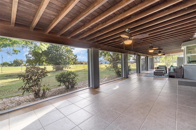 unfurnished sunroom featuring beamed ceiling and wood ceiling