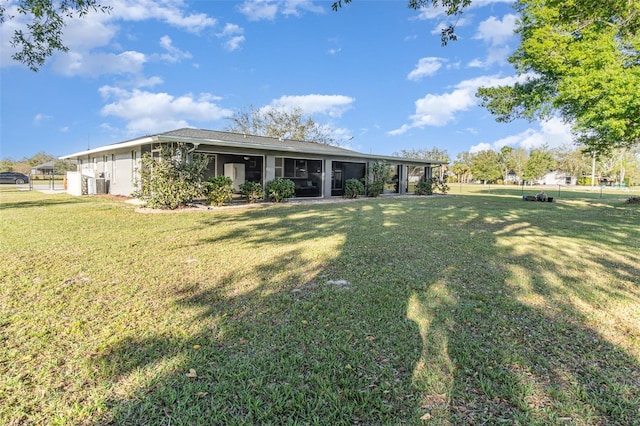 view of front of property with a sunroom and a front lawn