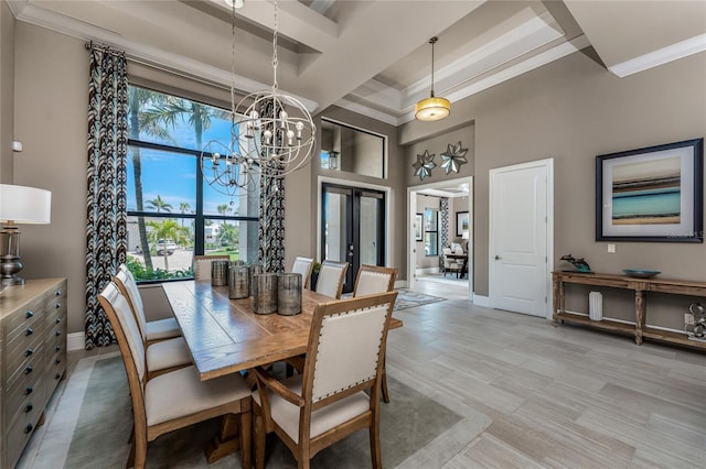 dining room featuring baseboards, ornamental molding, an inviting chandelier, a high ceiling, and light wood-style floors