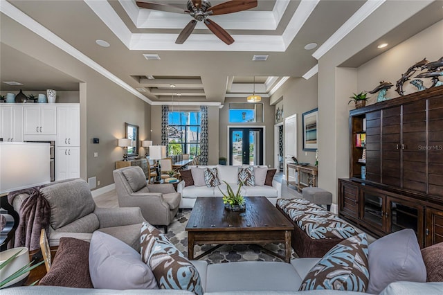 living room with ornamental molding, a tray ceiling, visible vents, and baseboards