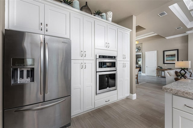 kitchen with light wood-type flooring, visible vents, stainless steel appliances, and open floor plan