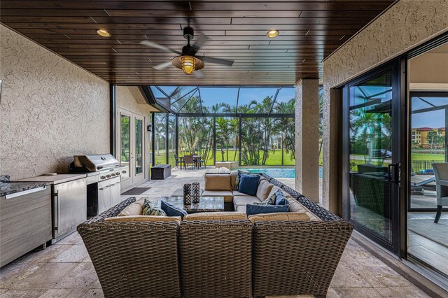 sunroom featuring wood ceiling and ceiling fan