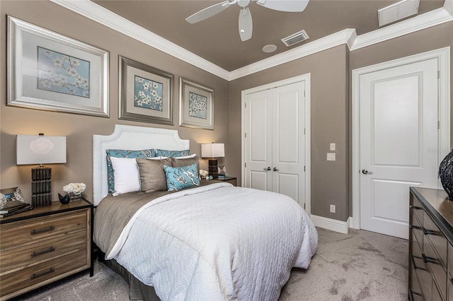 carpeted bedroom featuring a closet, visible vents, and crown molding