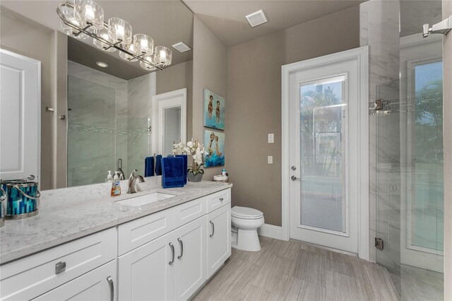 full bathroom featuring visible vents, baseboards, toilet, vanity, and a shower stall