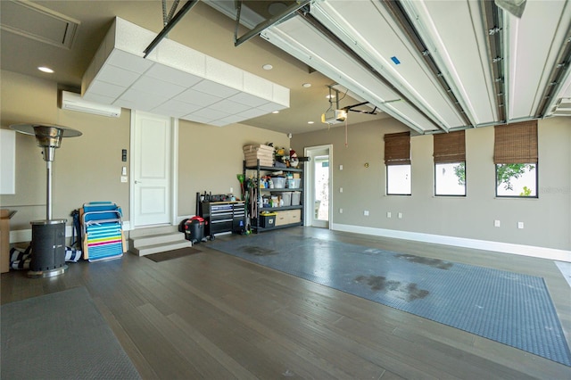 interior space with baseboards, an AC wall unit, and a garage door opener