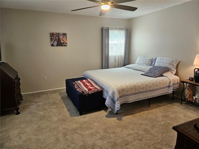 carpeted bedroom featuring a textured ceiling, a ceiling fan, and baseboards