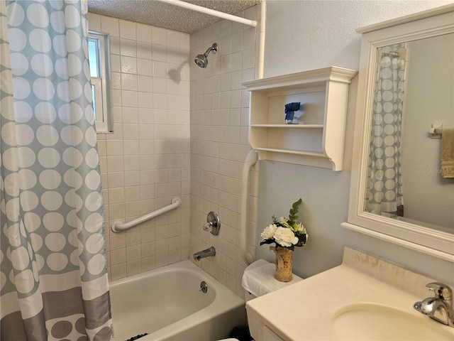 bathroom featuring shower / bath combination with curtain, vanity, and a textured ceiling