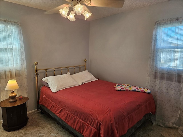 bedroom featuring a textured ceiling, carpet floors, ceiling fan, and baseboards