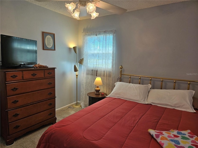 bedroom with baseboards, a textured ceiling, and light colored carpet