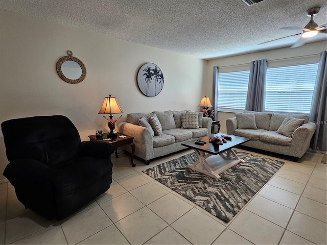 living area with light tile patterned floors, visible vents, a textured ceiling, and a ceiling fan