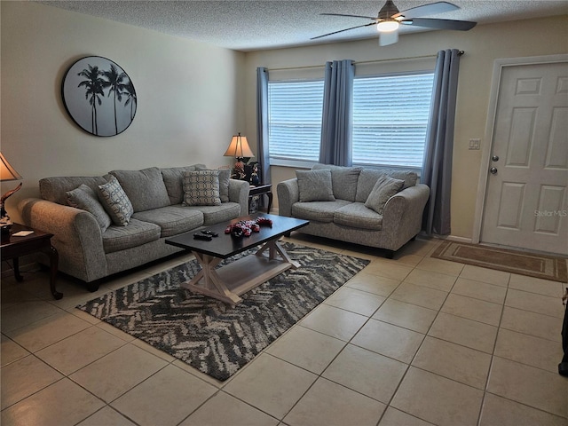 living area with a ceiling fan, a textured ceiling, and light tile patterned flooring