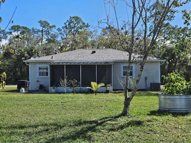 back of house with a sunroom, a shingled roof, central AC unit, and a lawn