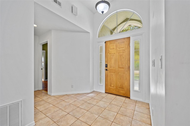 foyer featuring light tile patterned flooring, visible vents, and baseboards