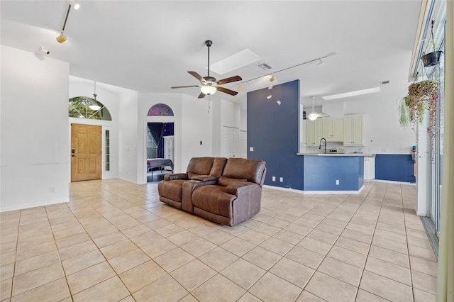 living area with visible vents, a ceiling fan, light tile patterned flooring, rail lighting, and baseboards