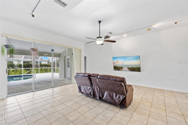 living room featuring visible vents, ceiling fan, rail lighting, a skylight, and light tile patterned flooring