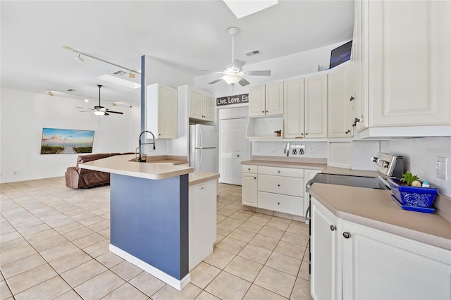 kitchen featuring a ceiling fan, visible vents, freestanding refrigerator, and a sink