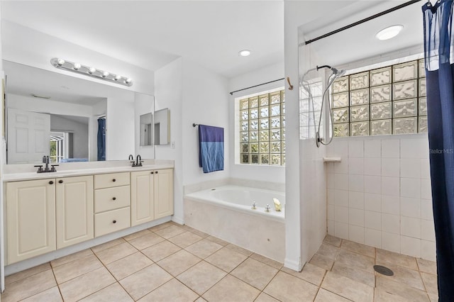 bathroom with tile patterned floors, a sink, double vanity, tiled shower, and a bath