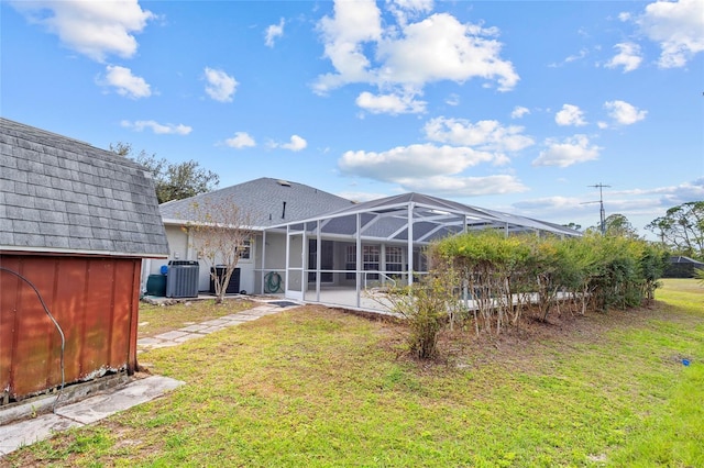 rear view of house featuring cooling unit, a yard, a storage shed, glass enclosure, and an outdoor structure