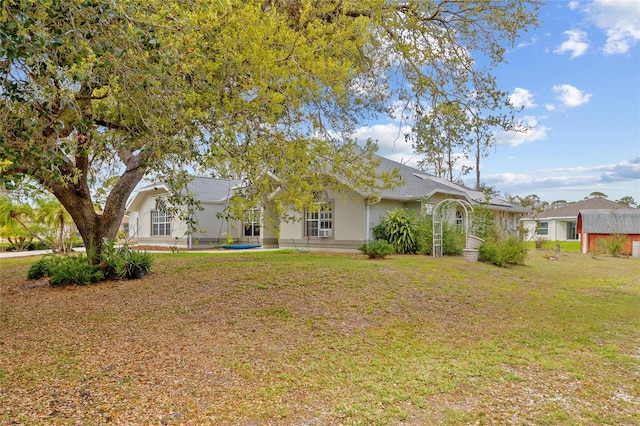 view of front of house featuring stucco siding and a front yard