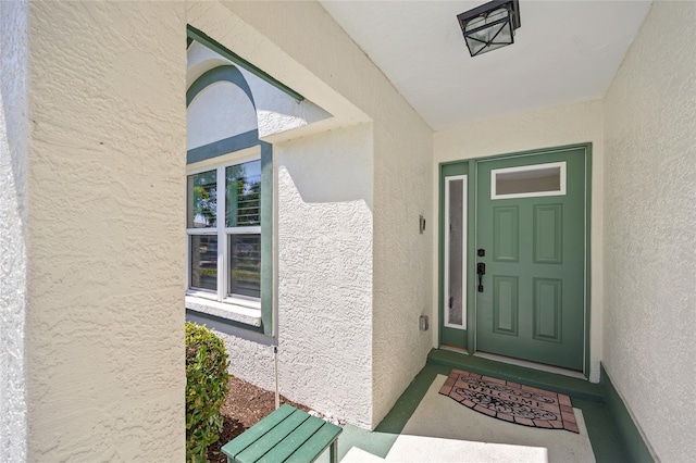 view of exterior entry featuring stucco siding