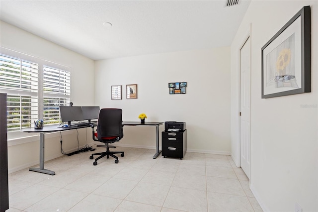 office space with light tile patterned floors, visible vents, and baseboards