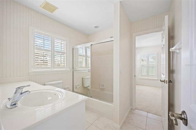 bathroom featuring visible vents, enclosed tub / shower combo, toilet, and tile patterned flooring