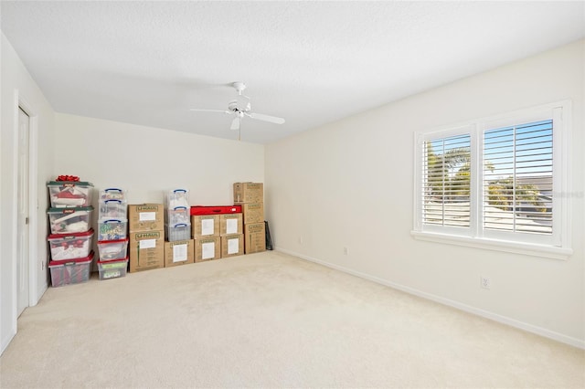 empty room featuring a ceiling fan, baseboards, a textured ceiling, and carpet flooring